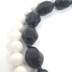 Immagine di Collana preziosa, elegante, conchiglia naturale bianca faccettata, onice nera a sasso, due fili, chiusura in argento bianco, artigianale